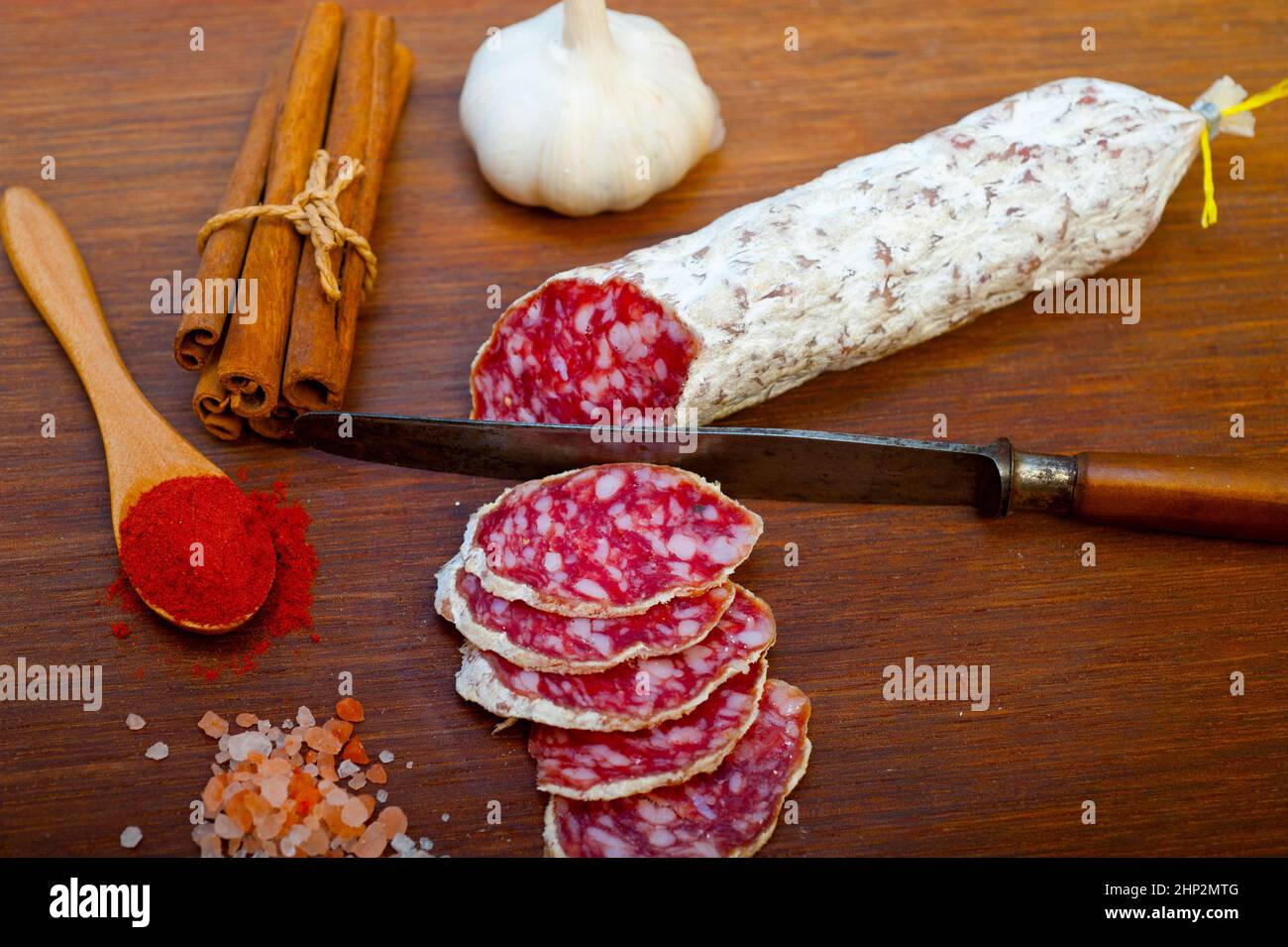 traditional Italian salame cured sausage sliced on a wood board Stock