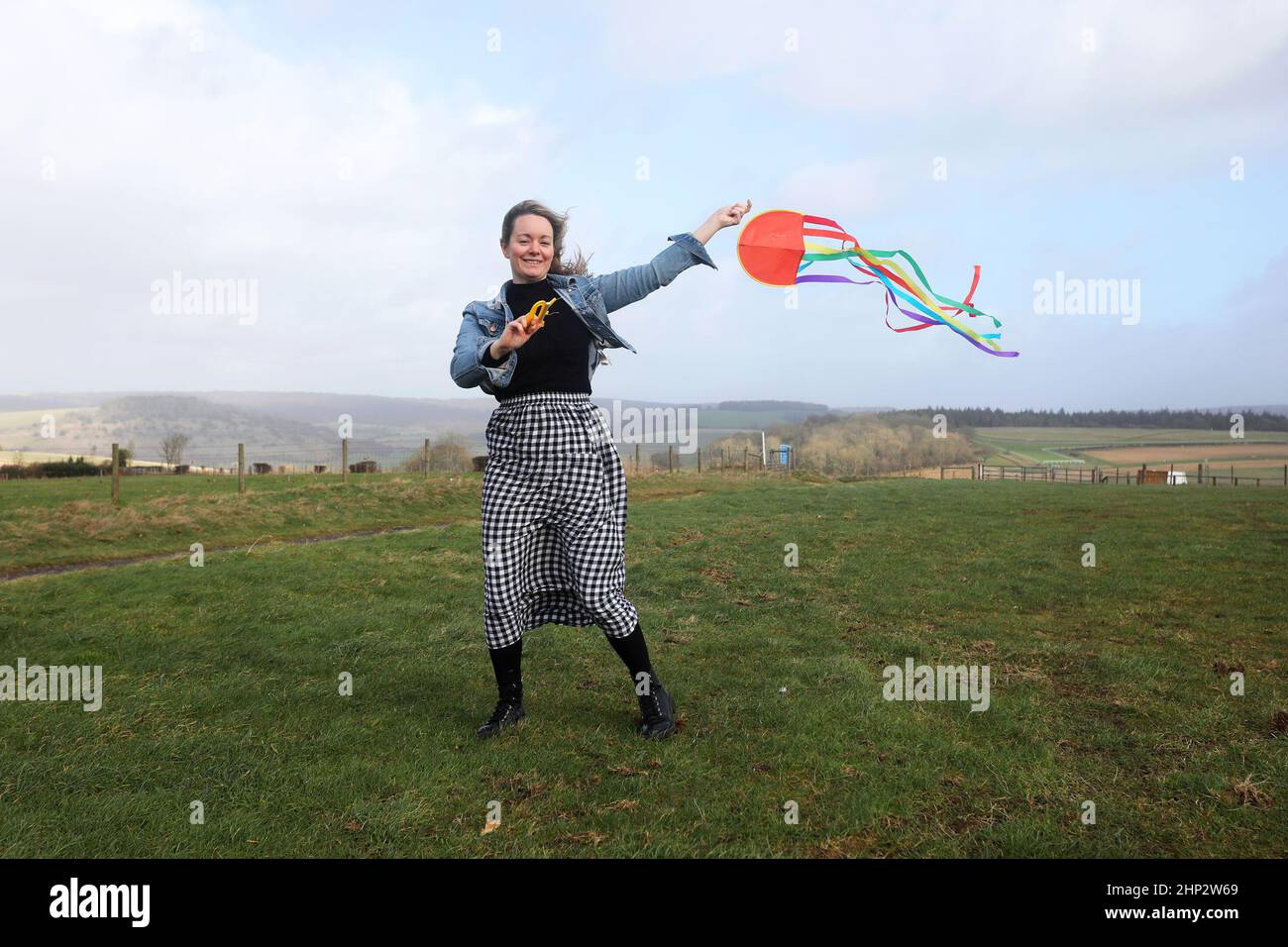 Chichester, West Sussex, UK. Kelly Daivs pictured braving Storm Eunice to fly a kite up on Goodwood hill, Chichester, UK. Credit: Sam Stephenson/Alamy Live News Stock Photo
