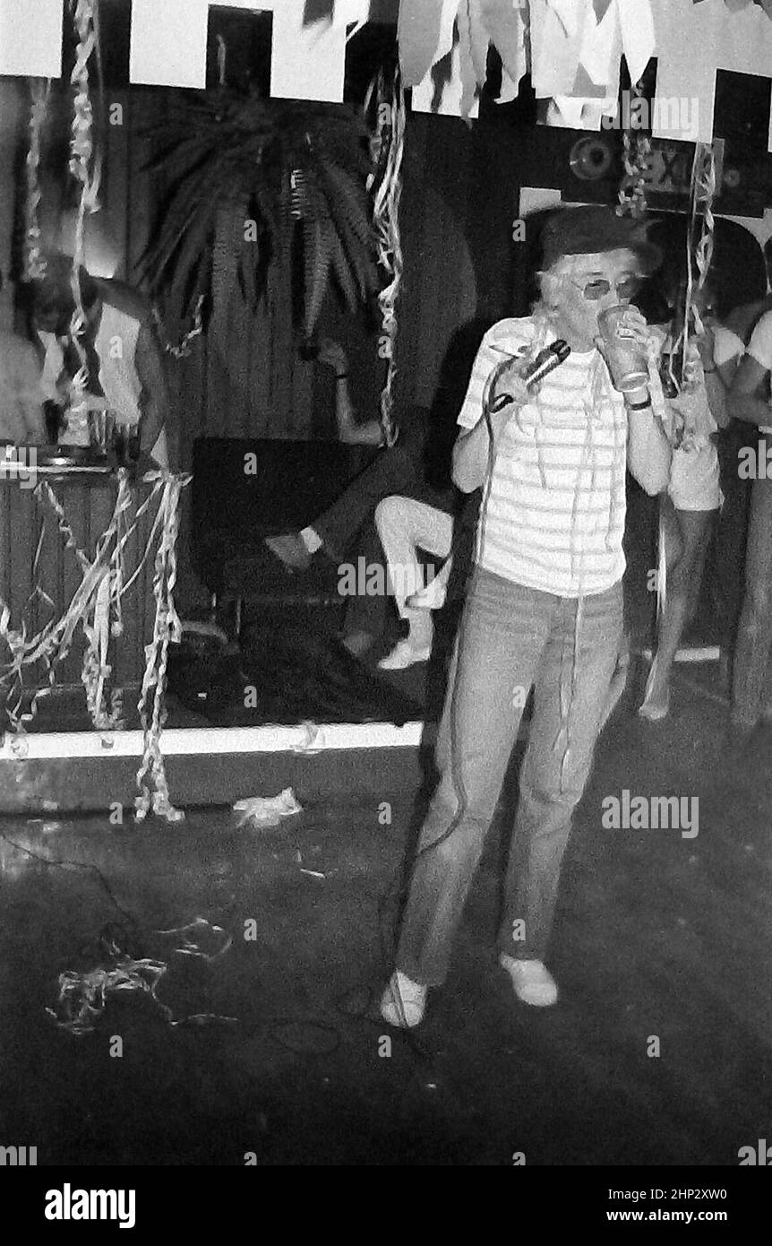 Comedienne Pat Mills performing at gay bar Stuffed Olives, Manchester, Greater Manchester, England, United Kingdom, in 1983. Daily life in the night life of Manchester's gay clubs and bars in the 1980's. A performer on the stage in a bar or public house popular with lesbians and gay men or LGBT people in  in the early 1980s. Stock Photo