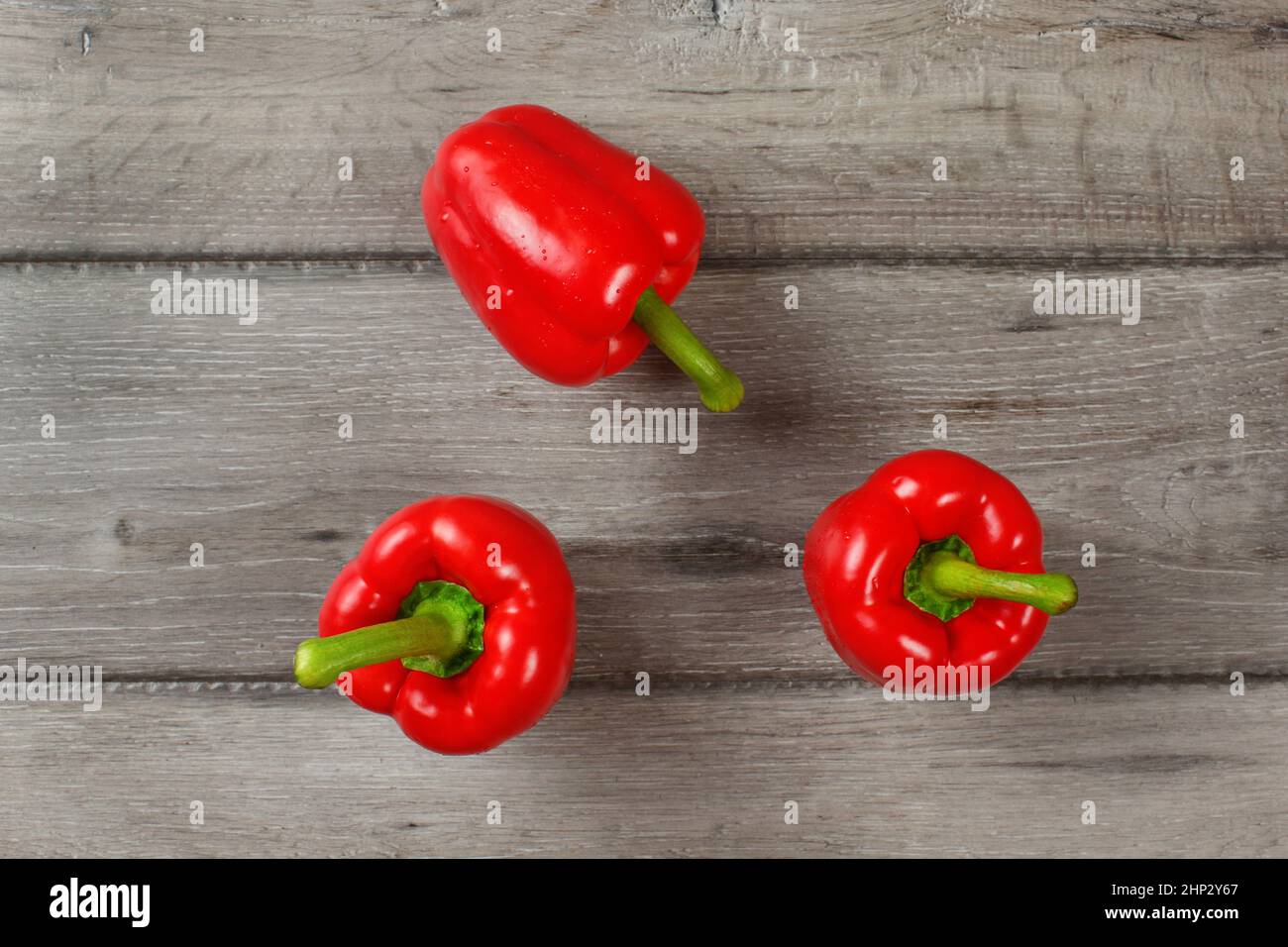 Tabletop view - three red bell peppers on gray wood desk Stock Photo ...