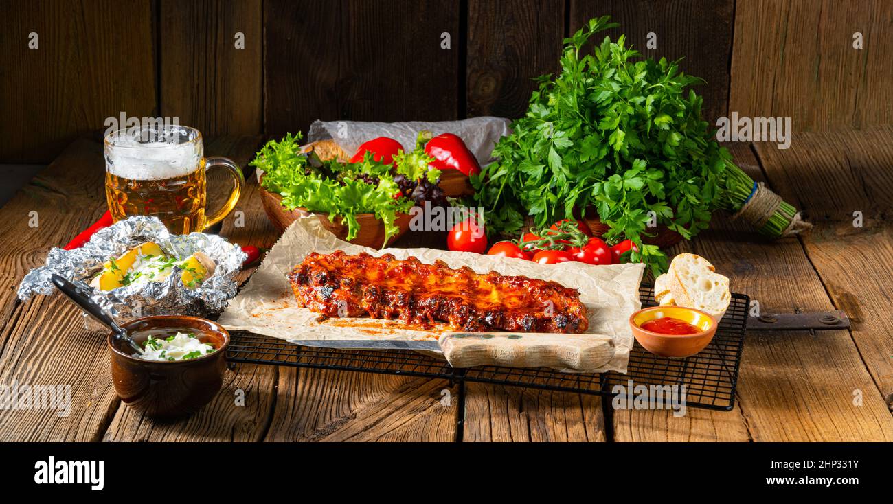 spicy spare ribs with baked potatoes and sour cream Stock Photo