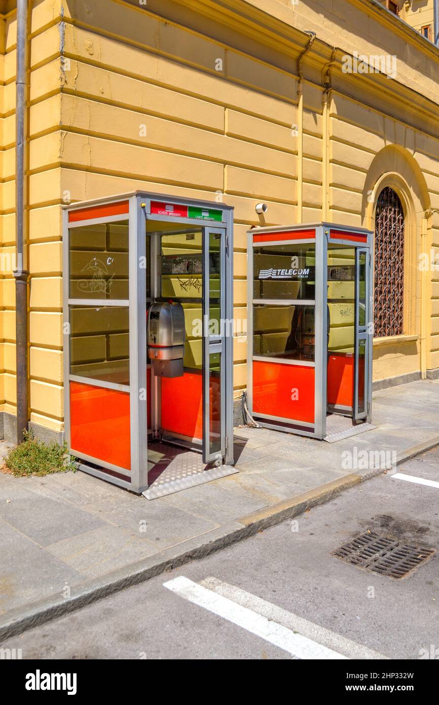 Fossano, Cuneo, Italy - July 16, 2016: Telecom Italia (TIM) phone boxes. Phone booths near of the old train station building Stock Photo