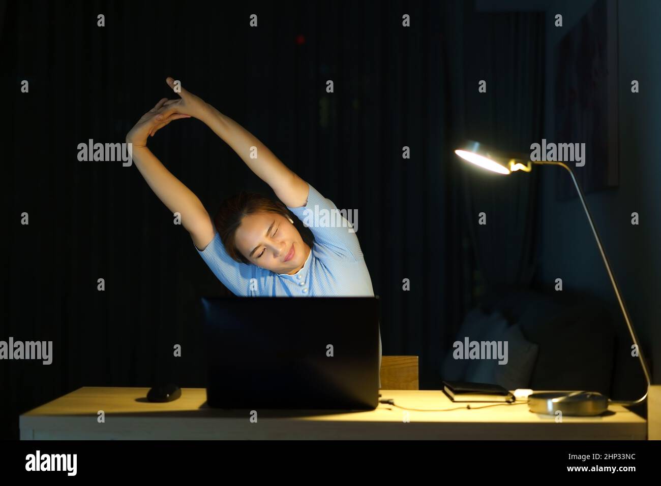 Asian woman are stretch lazily while working long hours in front of a