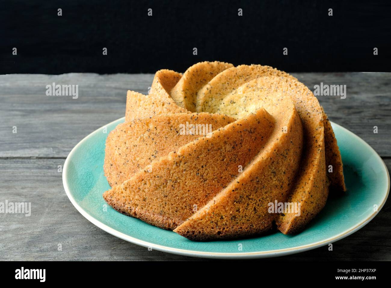 A home baked lemon drizzle and poppy seed cake. The cake mixture was baked in a Nordic ware Heritage Bundt tin to give a distinctive formed shape Stock Photo