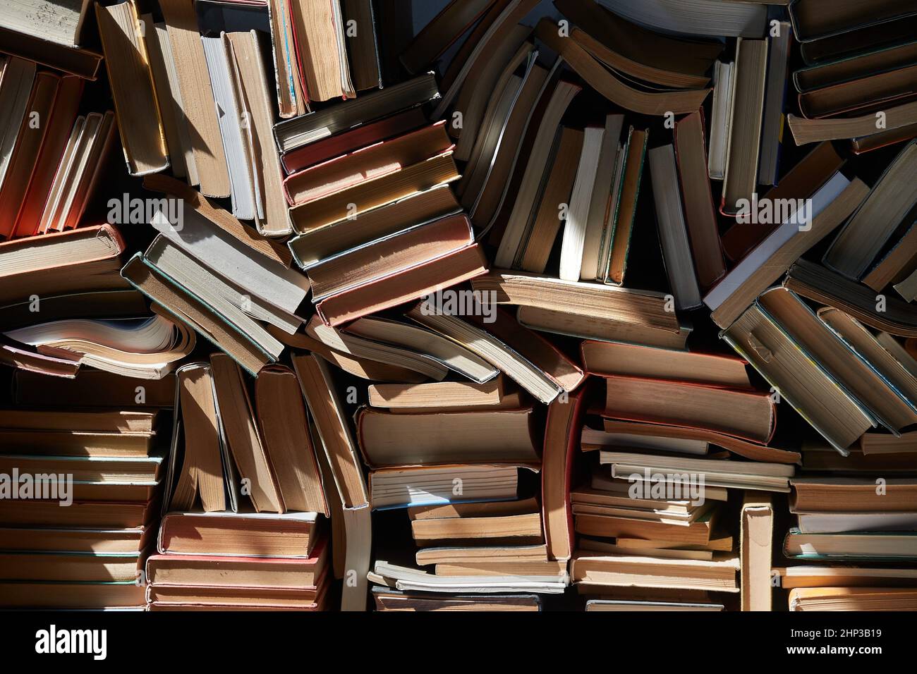 Pile of old books in dramatic dim light in the attic, forming book wall