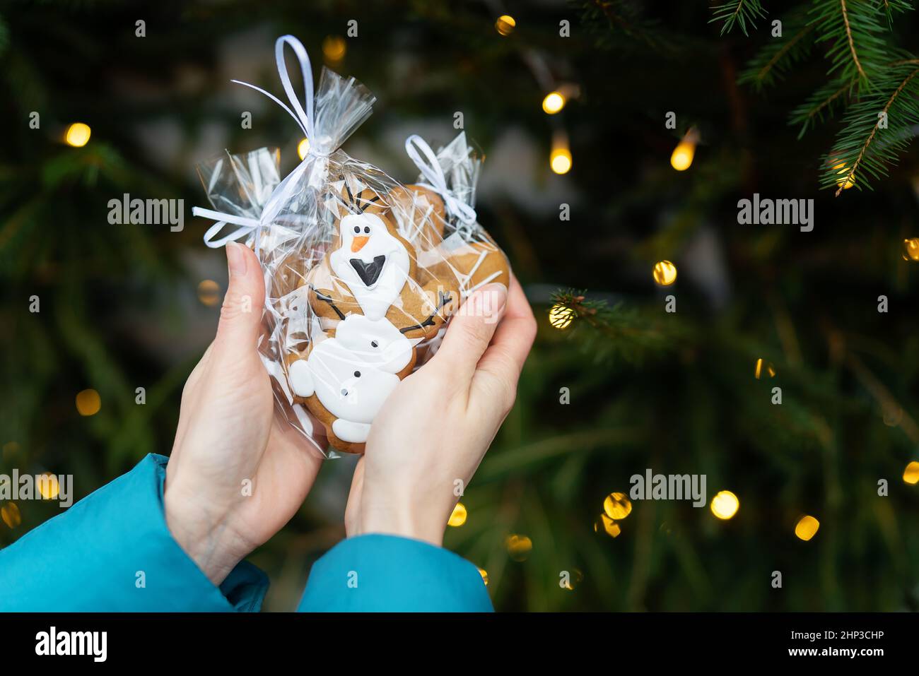 A Girl Holds Cookies On The Eve Of New Years And Christmas 2022-2023 On The Street Against The Background Of Garland Lights Stock Photo - Alamy