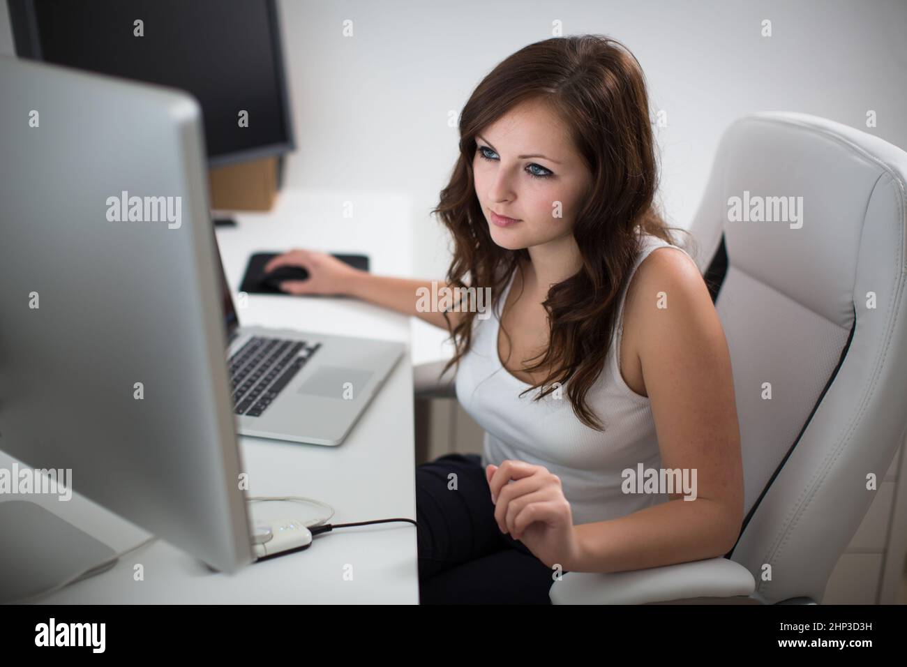 Young woman working on a computer in a home office Stock Photo