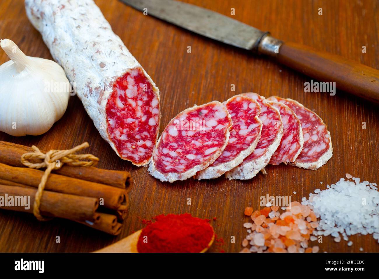 traditional Italian salame cured sausage sliced on a wood board Stock Photo