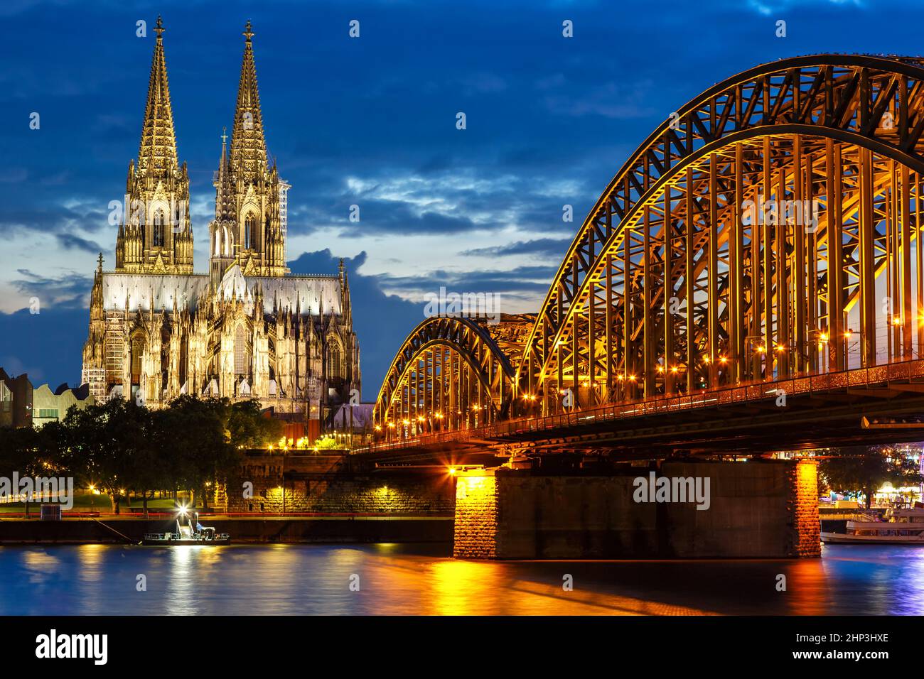 Cologne Cathedral city skyline and Hohenzollern bridge with Rhine river in Germany at twilight night Stock Photo