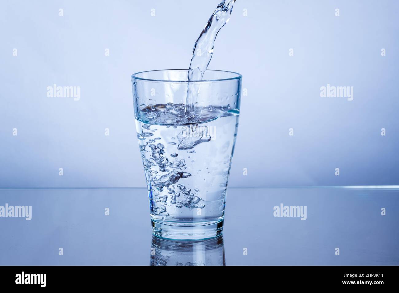 Pouring drink mineral water into a glass pour Stock Photo
