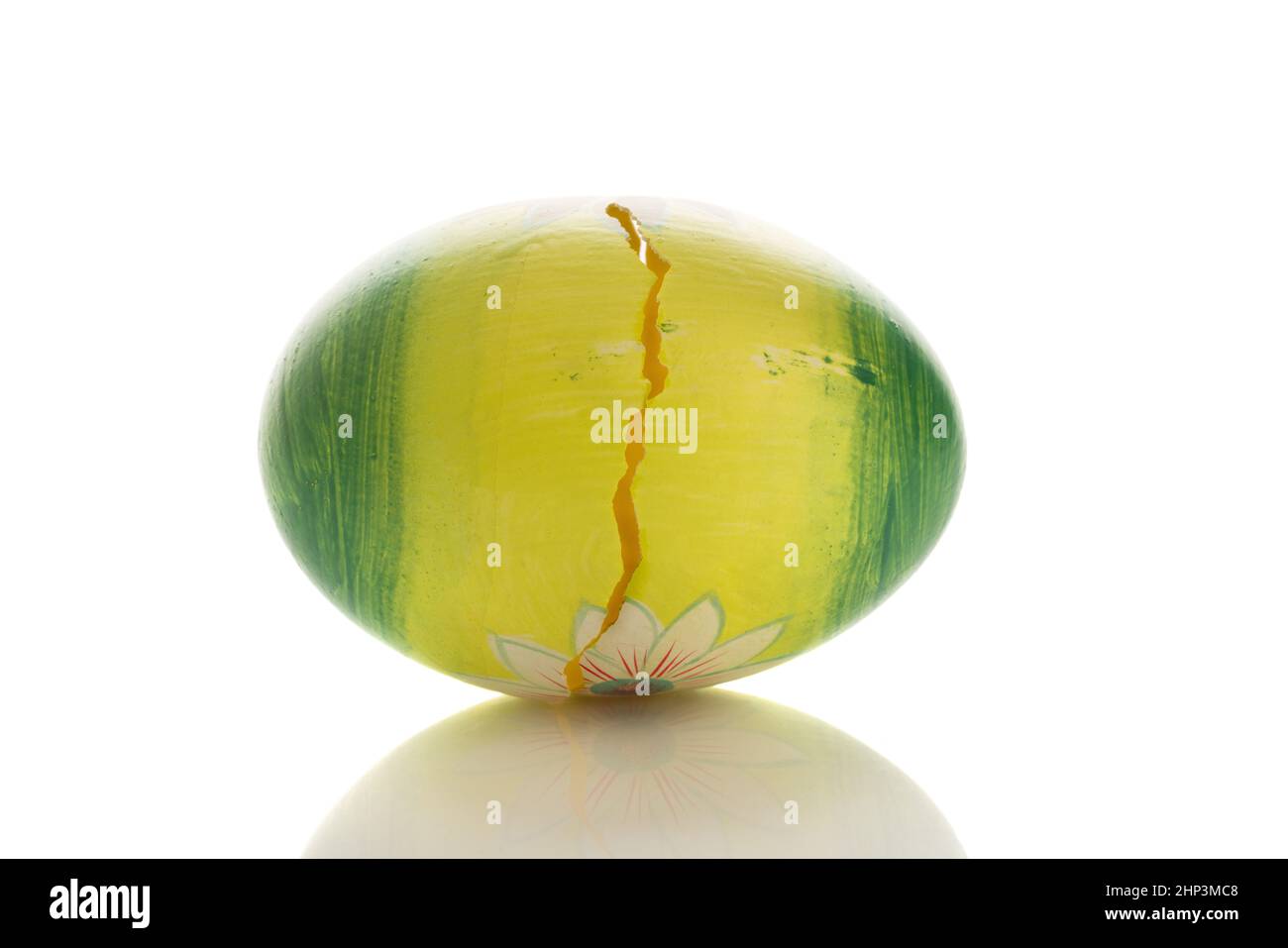 Green painted easter egg with a crack in it Stock Photo