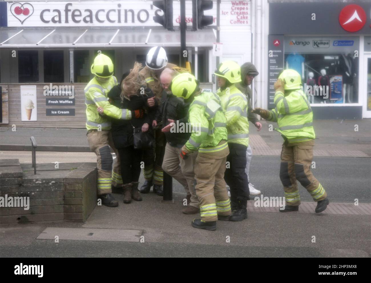 Newquay, UK. 18th February 2022. Eunice Red zone coastal town bears brunt of the storm. A woman was knocked down on the Narrowcliff road by severe wind and clung to a rail until passers by rushed to her aid, a team from Cornwall fire and Rescue were securing loose shop fronts nearby and seeing the situation dashed to take control.  Robert Taylor Alamy Live News Stock Photo