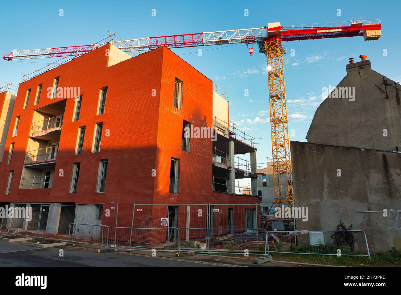 a crane at a construction site of a new apartment building with a balcony Stock Photo