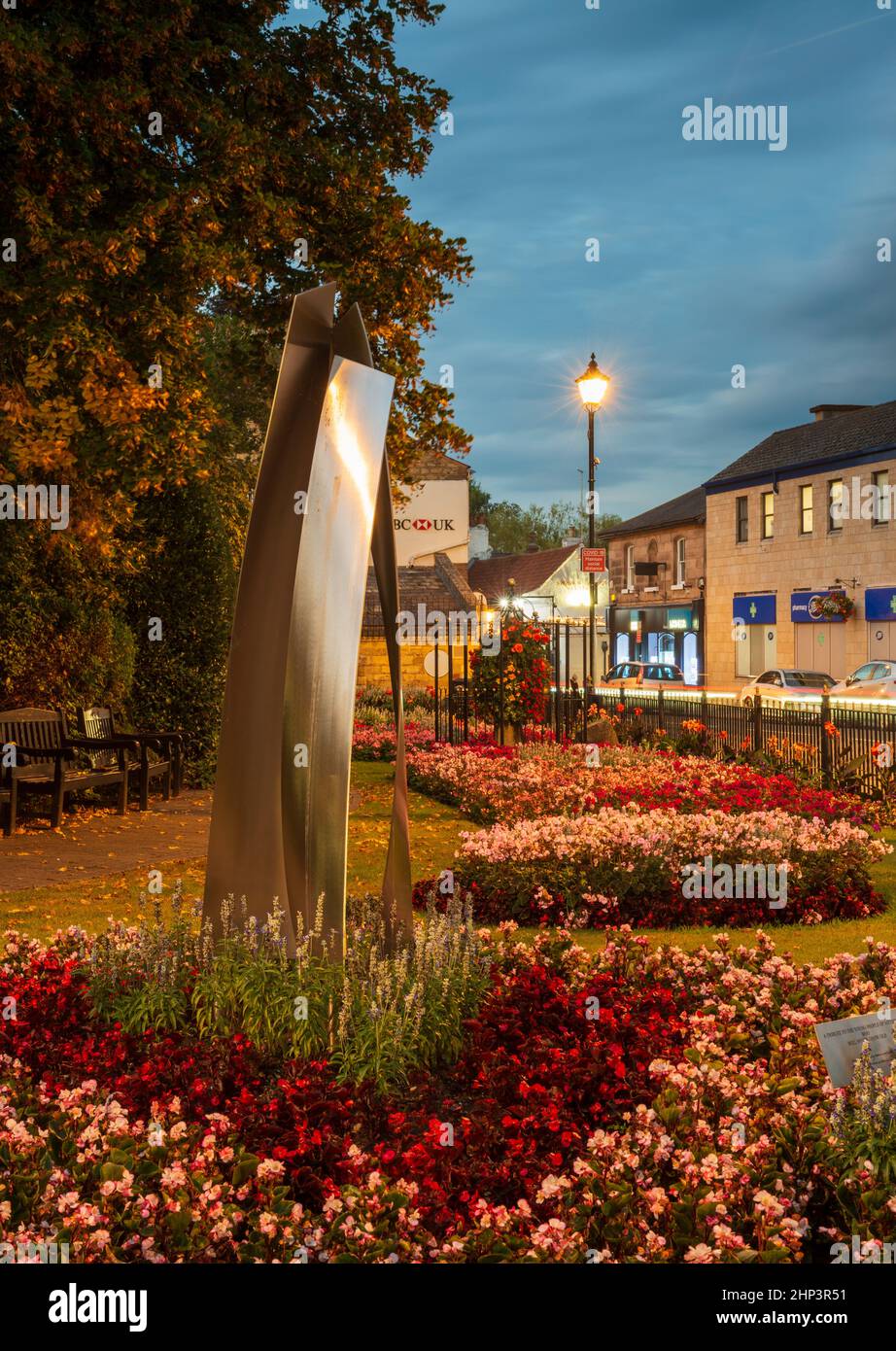 Evening view of the Garden of Rest in the centre of Wetherby, West Yorkshire with a stainless steel sculpture in the foreground Stock Photo