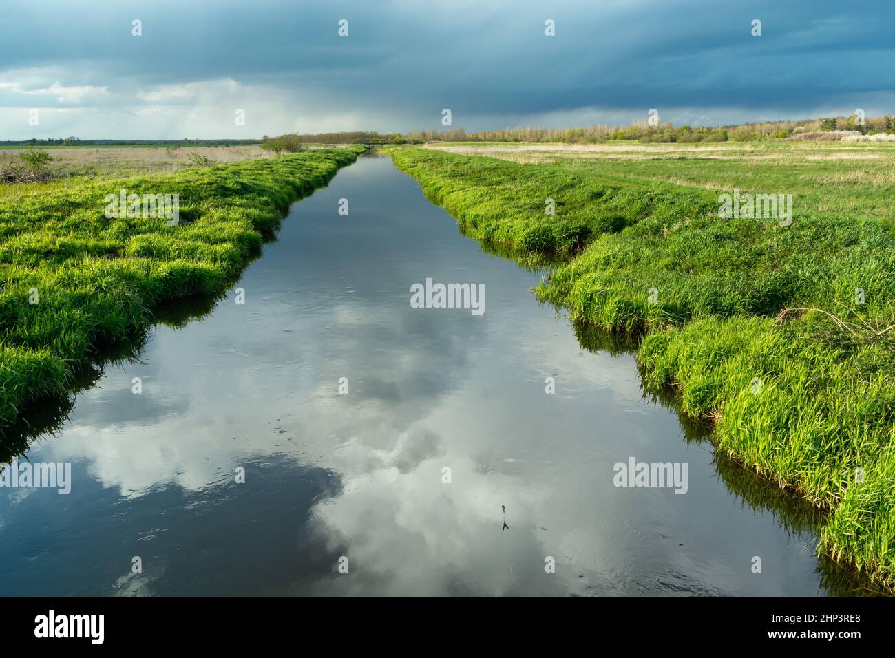 Reflection of clouds in a calm river with a green bank, Czulczyce, Lubelskie, Poland Stock Photo