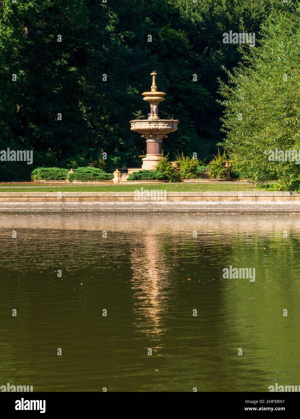 The Victorian teracotta fountain in South Park in Darlington reflected in the lake Stock Photo