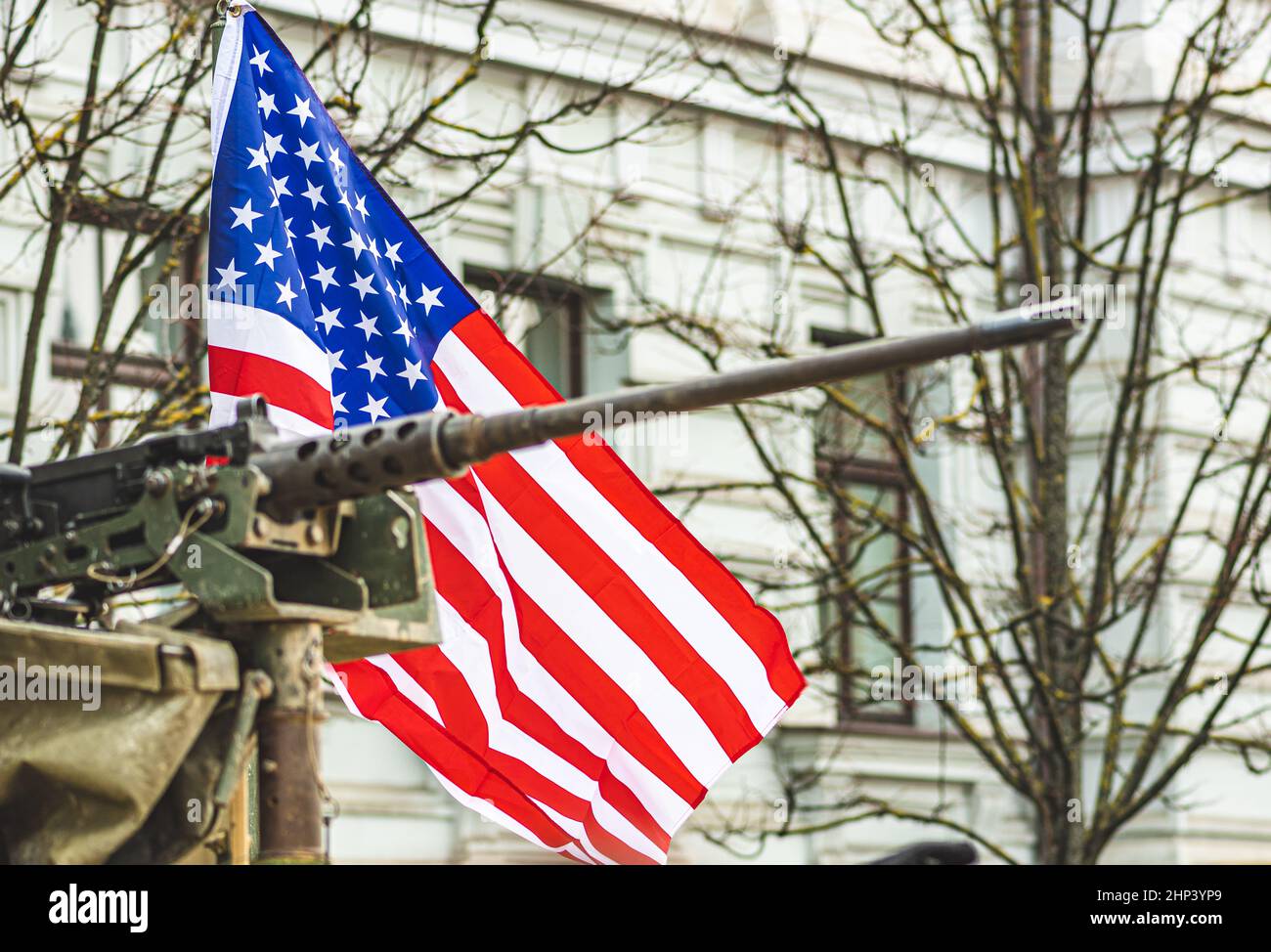 Machine gun mounted on United States Marine Corps forces tank or military vehicle, USA or US army, with American flag waiving on background Stock Photo
