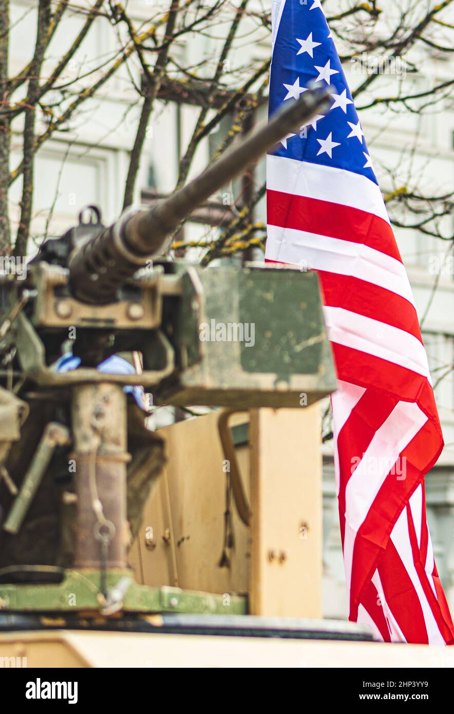 Machine gun mounted on United States Marine Corps forces tank or military vehicle, USA or US army, with American flag waiving on background, vertical Stock Photo