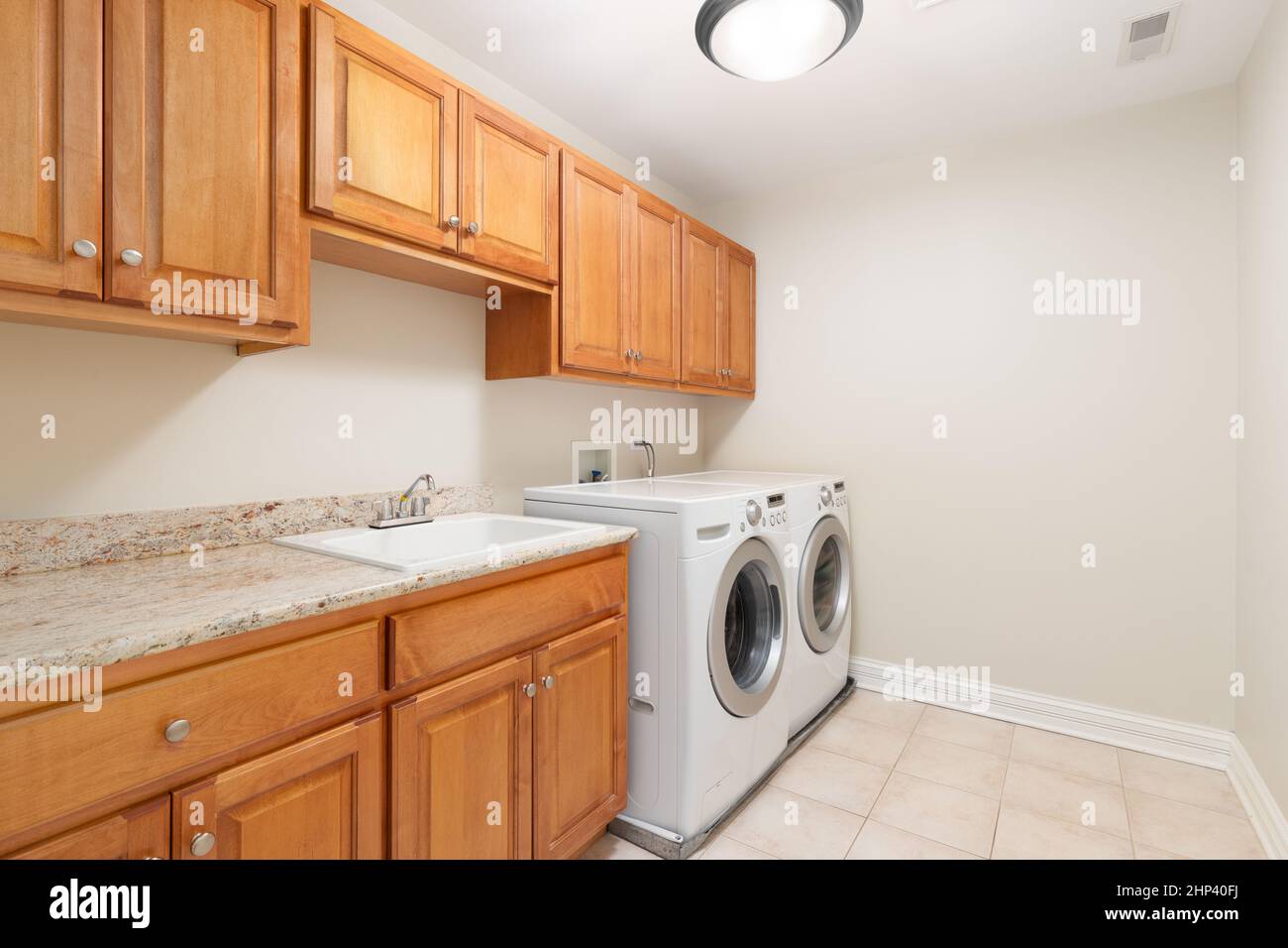 A large laundry room with wood granite countertop, and white