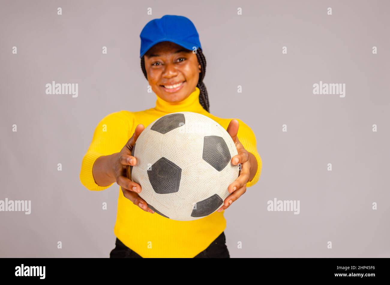lady isolated over white background pointing out the ball she is holding Stock Photo