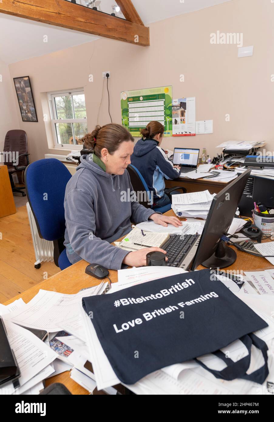 Farmers working in the farm office, with piles of paperwork and