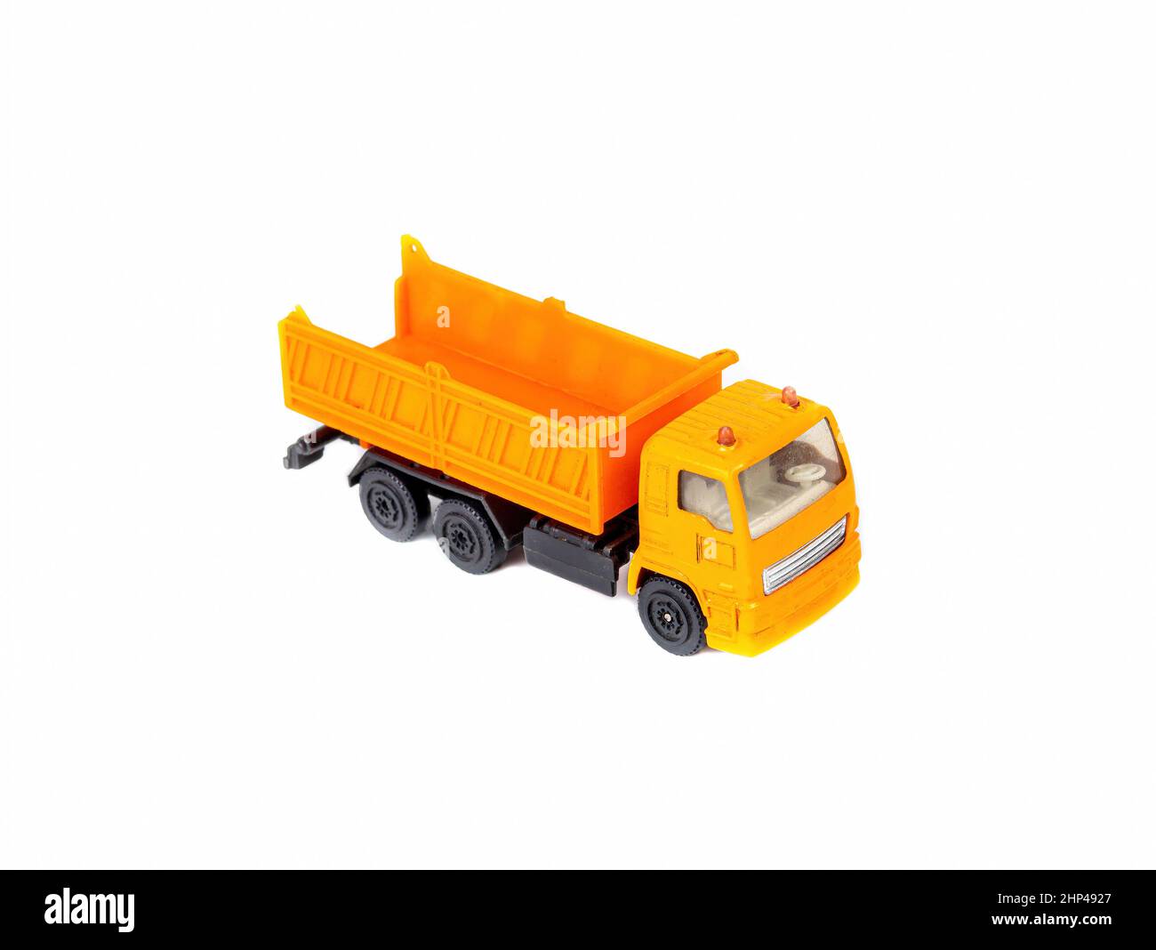 Orange lorry dump truck - children's toy on a white background. Dump truck lorry. Freight transport business. Motor vehicle. Construction transportati Stock Photo