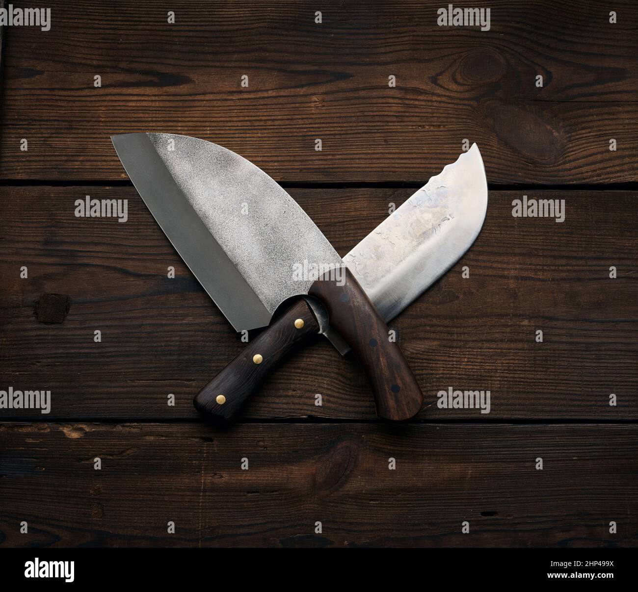 metal sharp kitchen knives in a wooden handle on a brown table made of