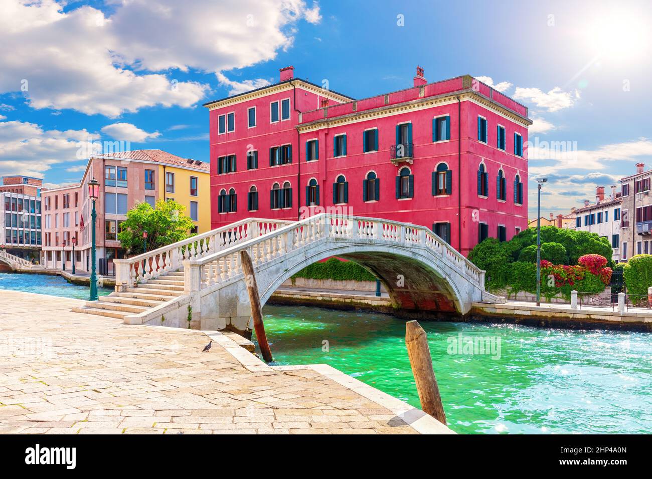Bridge of Venice near a typical old palace, view from the canal, Italy. Stock Photo