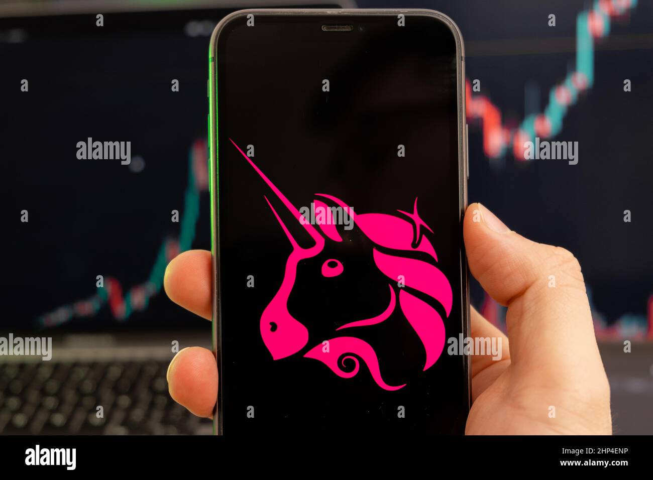 Uniswap UNI cryptocurrency logo on the screen of a smartphone in mans hand  with a growing trend on the chart on a green background Stock Photo - Alamy