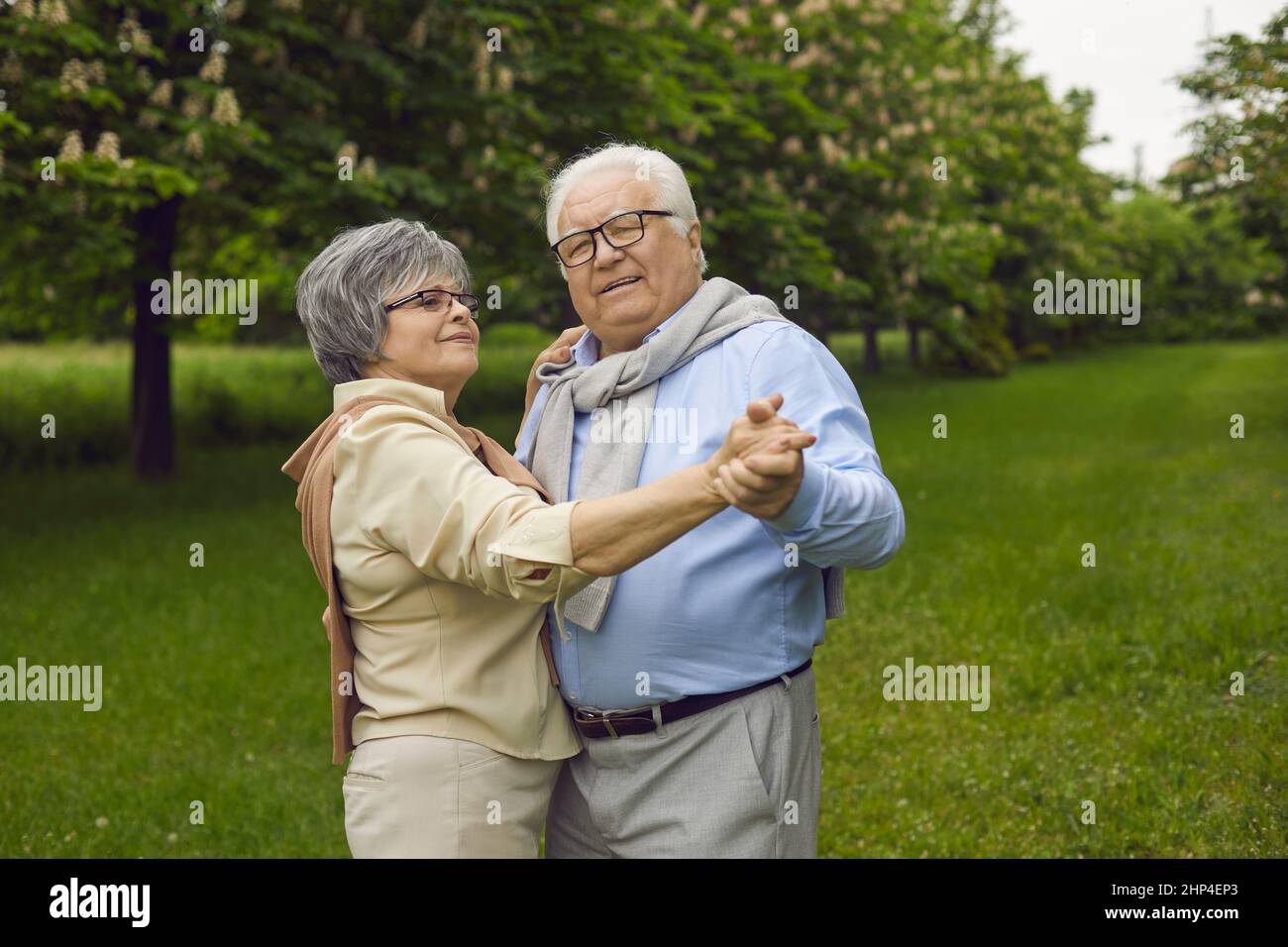 Happy loving mature senior couple dancing in park enjoy time together outdoors Stock Photo