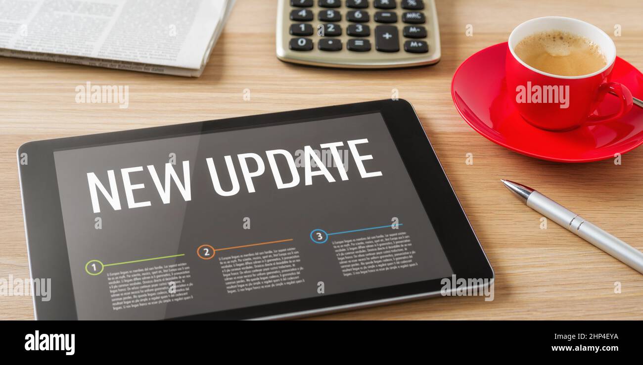 A tablet on a desk with the headline New update Stock Photo
