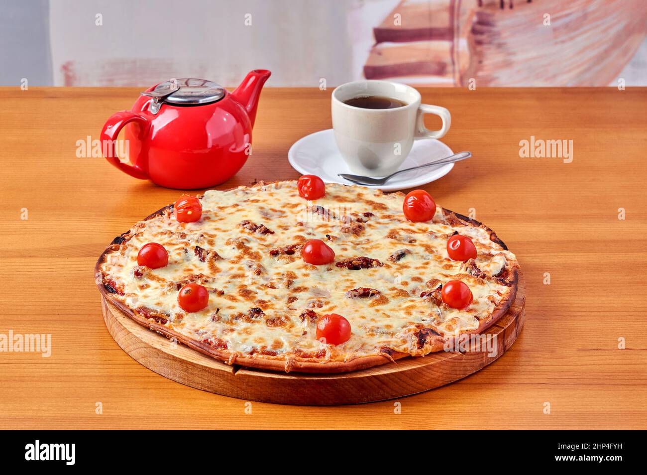 pizza Lombardy lies on a stand with tea and a kettle. High quality photo Stock Photo