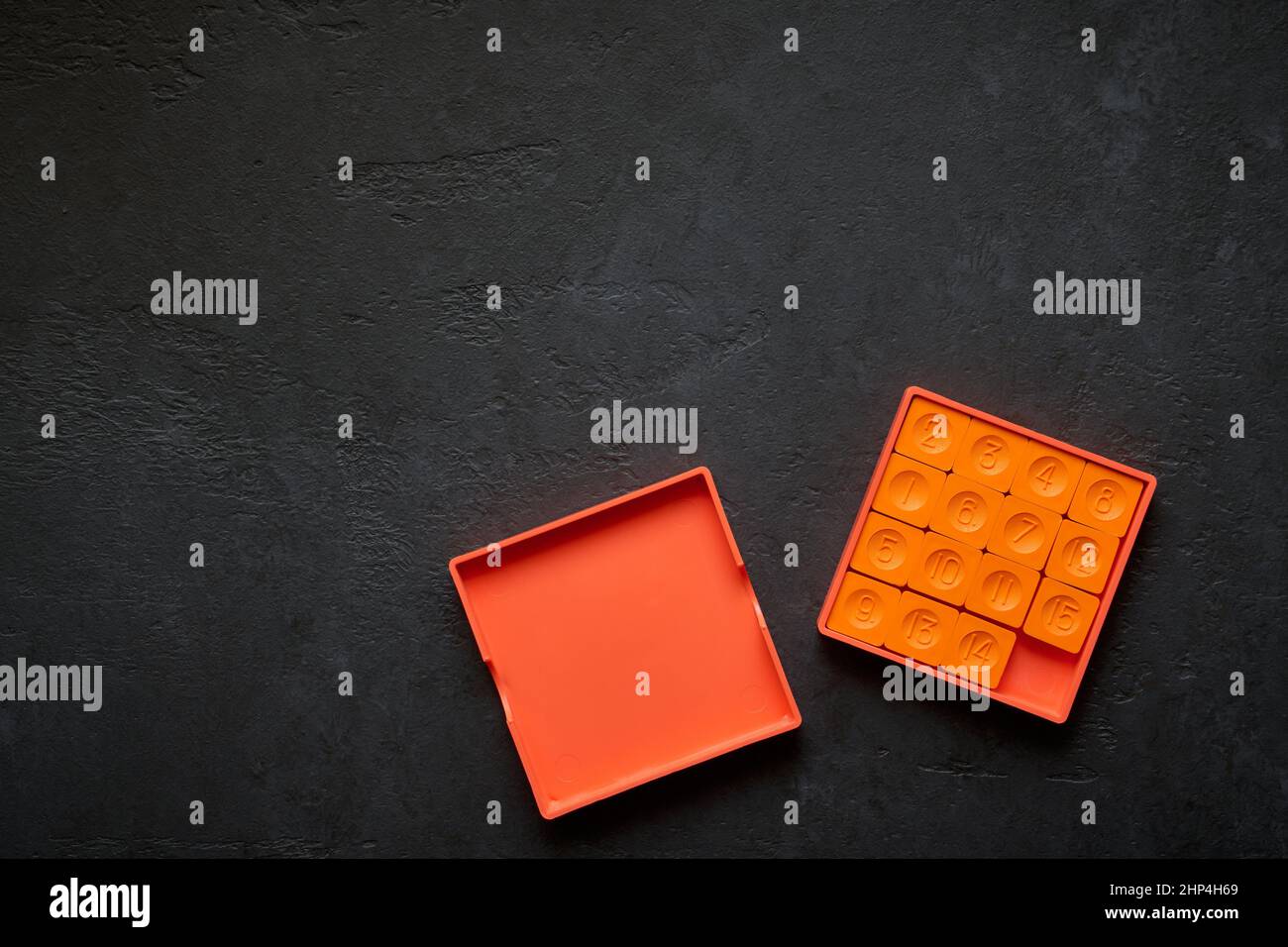 Pocket sliding puzzle with fifteen chips on a dark background Stock Photo