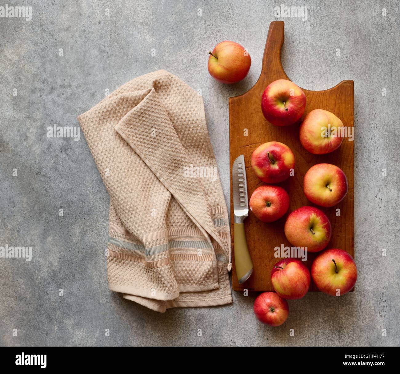Red ripe apples on wooden board on gray stone table, top view Stock Photo