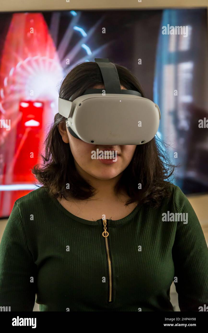 Faderlig udbrud bomuld Girl with VR headset playing with friends in virtual reality and projecting  it on tv-screen behind her, London, UK Stock Photo - Alamy