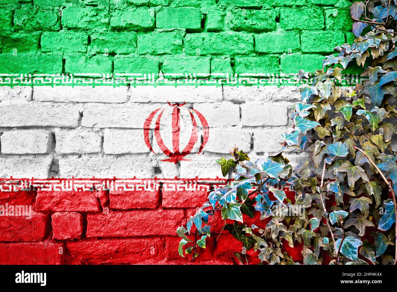 Iranian grunge flag on brick wall with ivy plant, country symbol concept of Iran Stock Photo