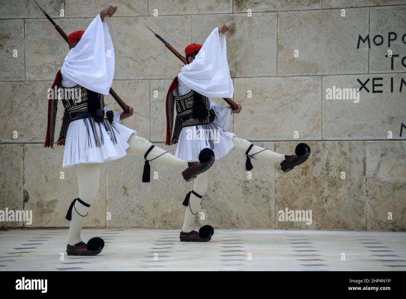 Greek Evzones (Presidential Guards) during the changing of the guards at the Tomb of the Unknown Soldier in Syntagma Sq. ahead of the Greek Parliament. Stock Photo