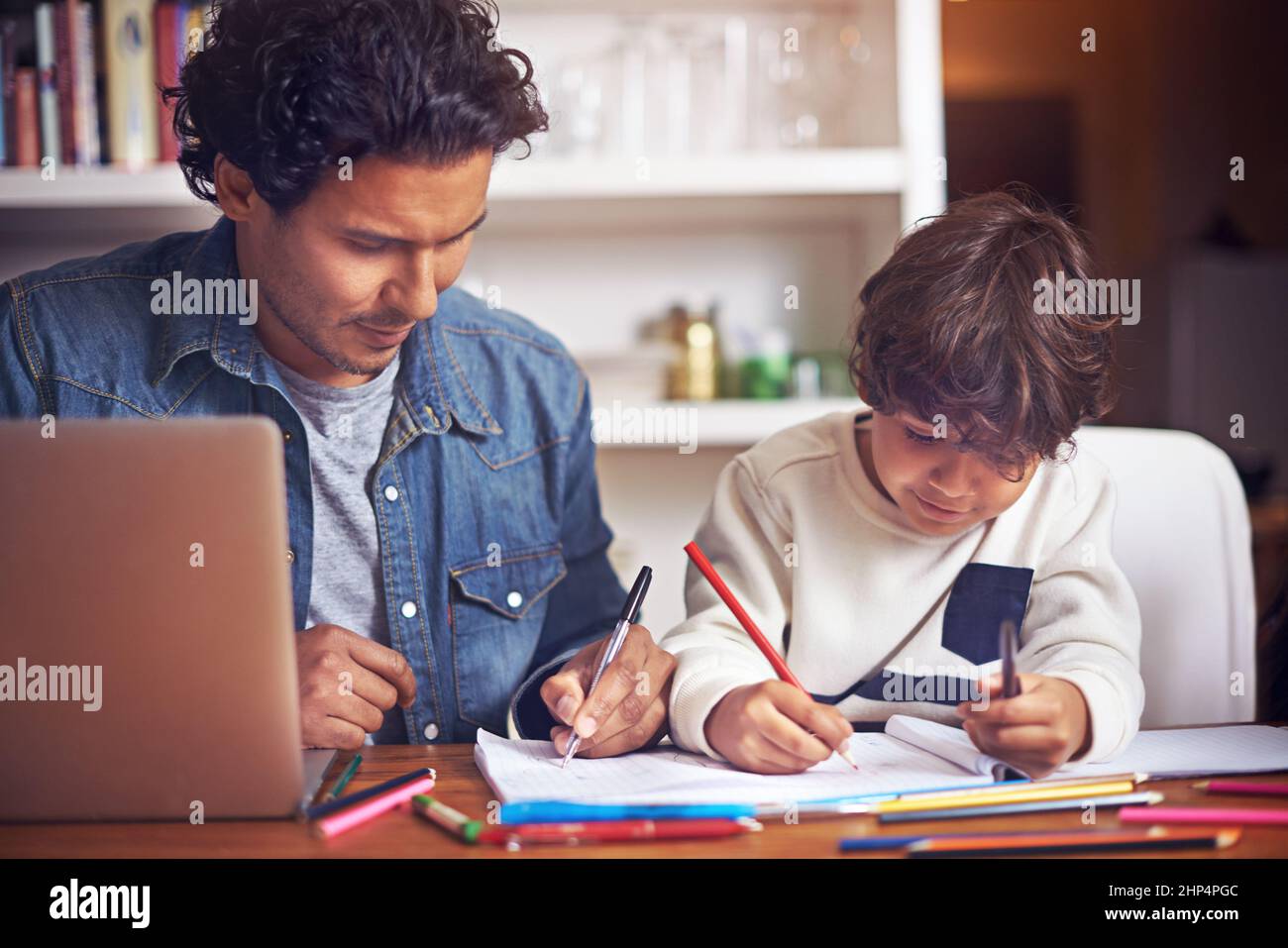 Youre doing a great job, son. Shot of a father helping his son with his ...