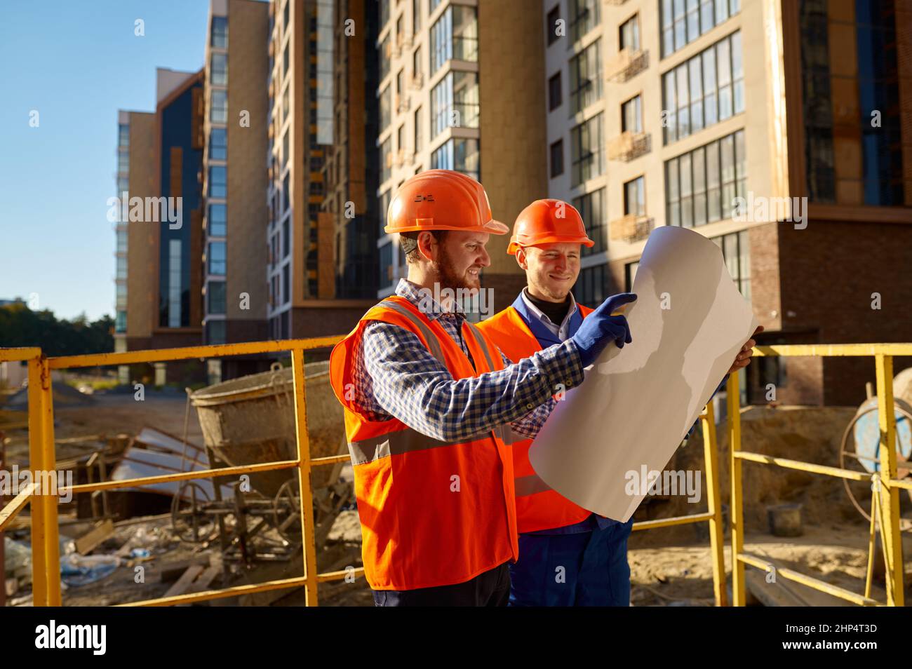 Builder contractor and engineer architect discussing blueprint paper project plan. Construction site Stock Photo