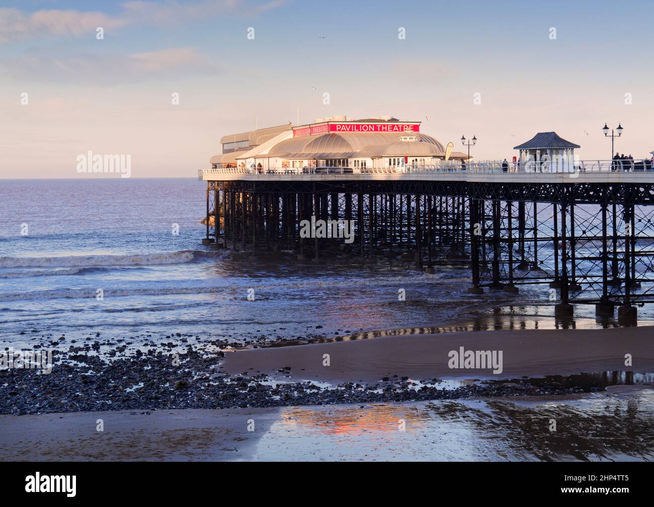 The iconic Cromer (Norfolk)  pier in low winter sunshine, January 2021 in calm seas on an ebb tide Stock Photo