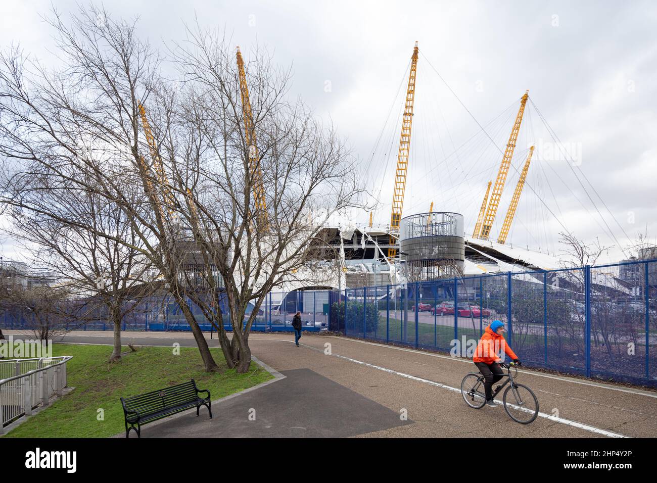 Man Cycles Past Londons 02 Arena, Ripped Open By Storm Eunice 18/02/2022 Stock Photo