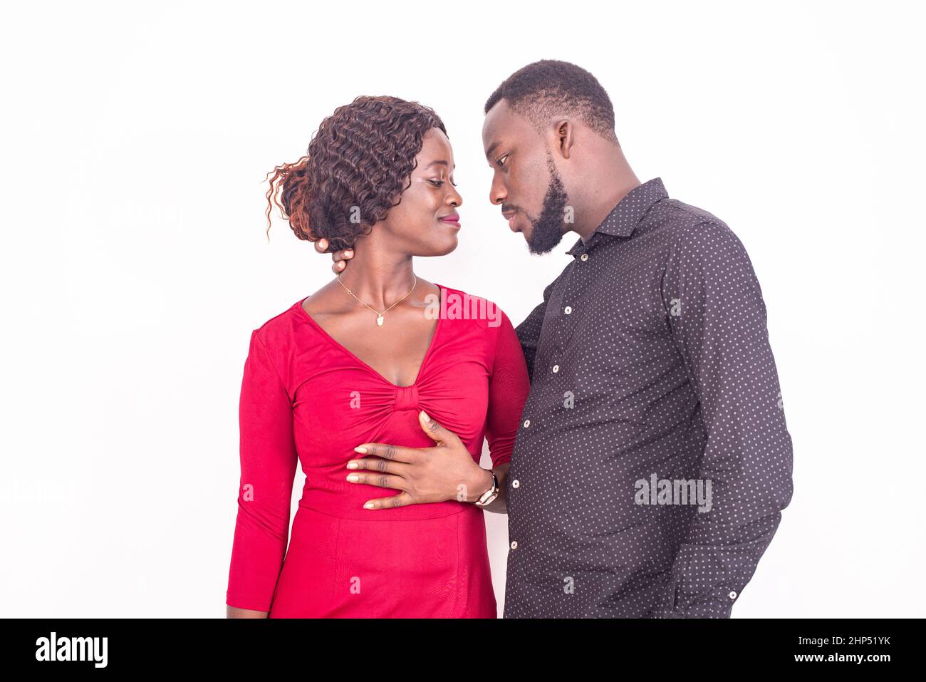 a beautiful young african couple standing on a white background going ...