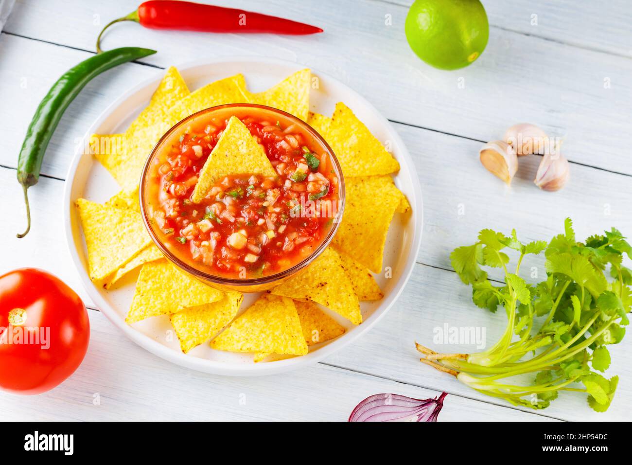 Mexican salsa sauce and nacho chips on white plate. Homemade salsa dip