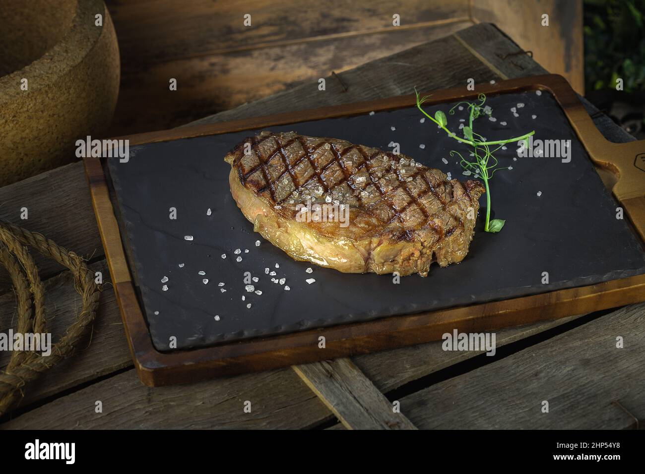 ribeye steak lezhin on a stone and wooden stand, decorated with ...