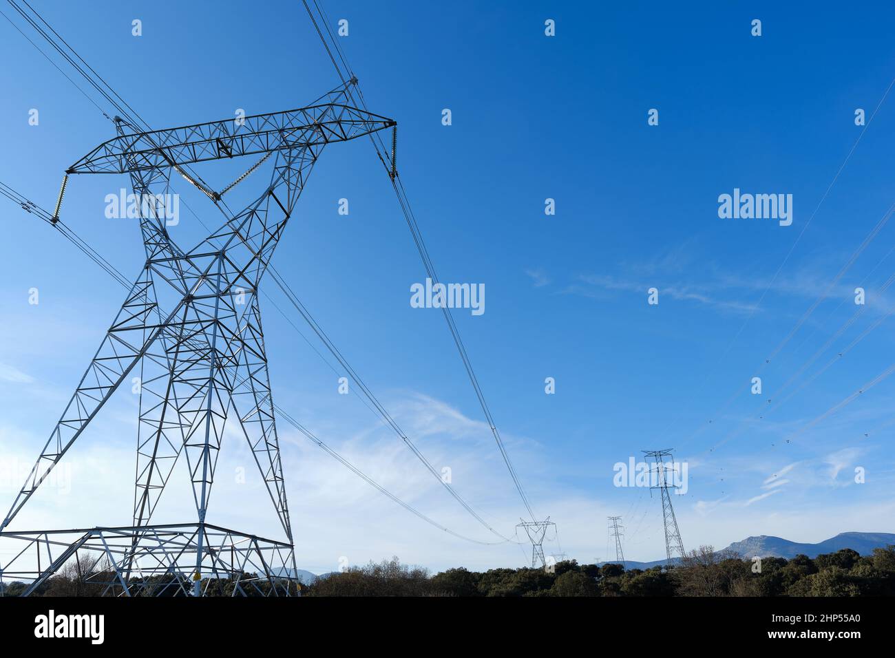 High voltage towers with electricity transmission power lines in field ...