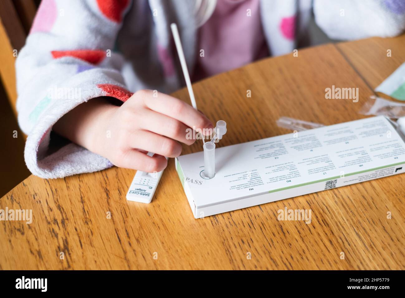 Child testing herself for coronavirus at home. Rapid COVID-19 Antigen test kit for self testing. Stock Photo