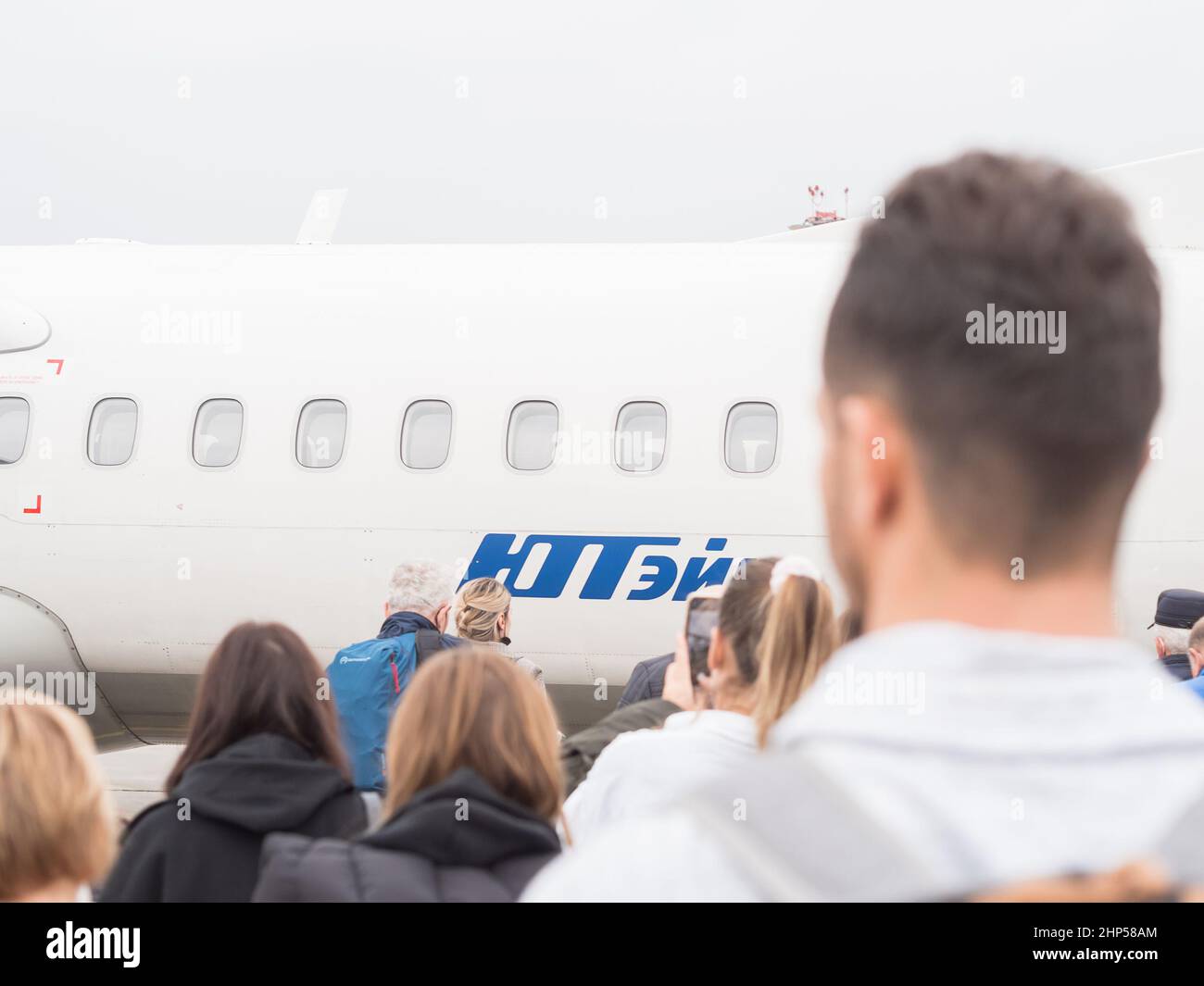 Russia, Sochi 02.11.2021. Passengers go to a mini plane with the inscription Utair. Selective focus. Boarding the plane Stock Photo