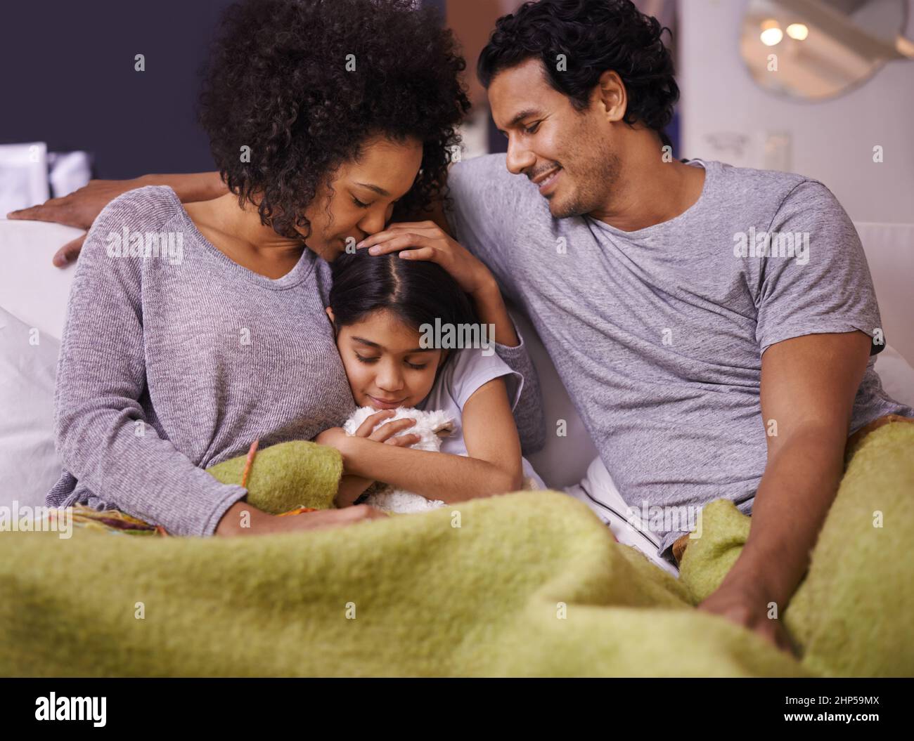 She brings them nothing but joy. Shot of a mother and father reading to their daughter. Stock Photo