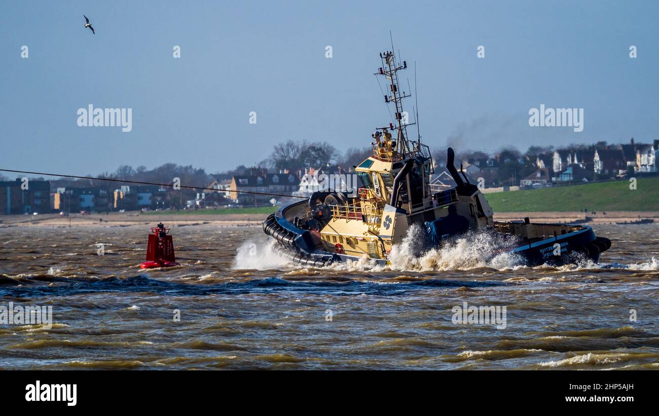 Svitzer Tug working to control a container ship at the Port of Felixstowe  UK during heavy winds. - Svitzer Tugs Stock Photo