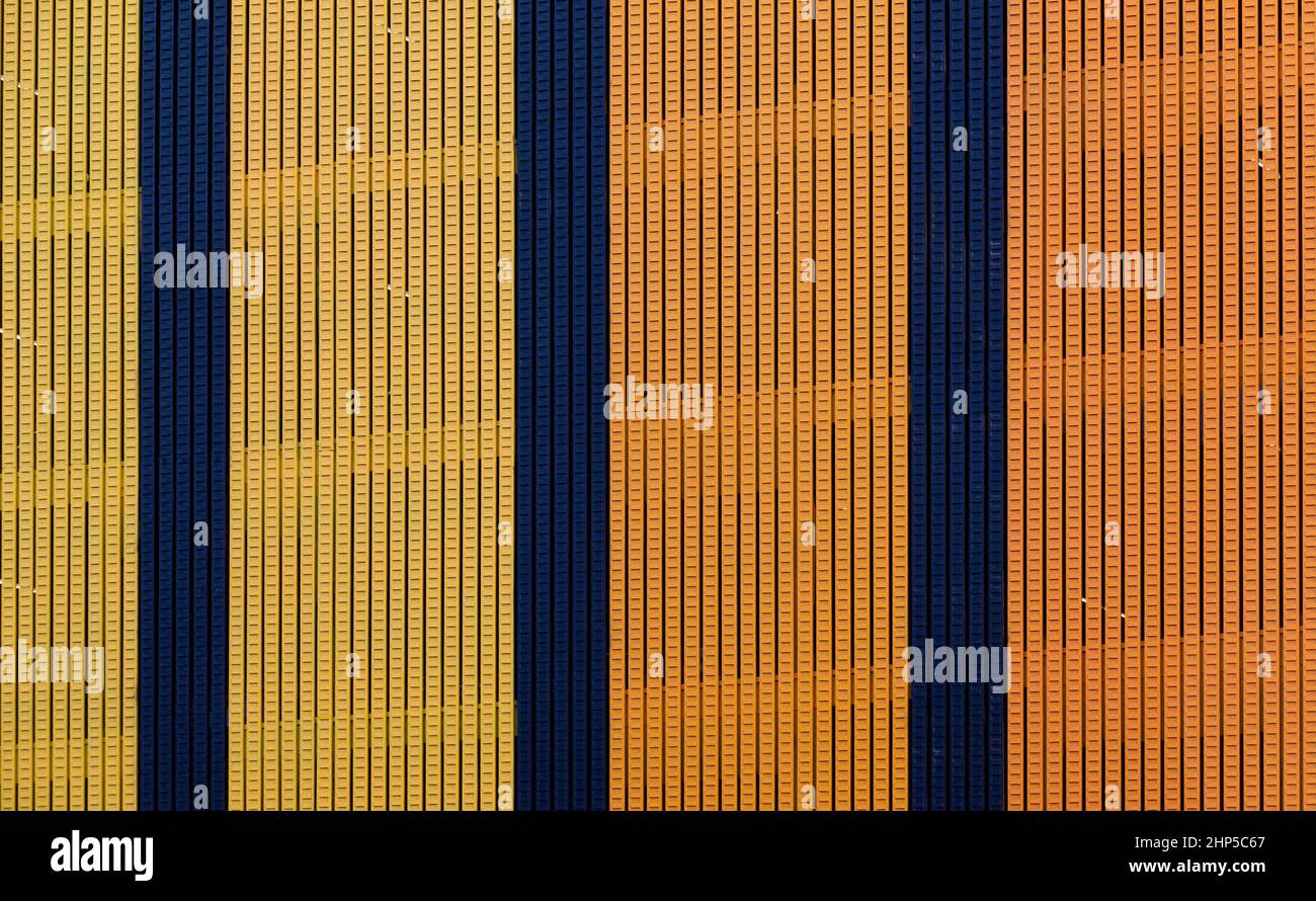 A Los Angeles building is covered with colorful and grooved panels. The bright yellow and orange panels and divided by panels of dark blue. Stock Photo
